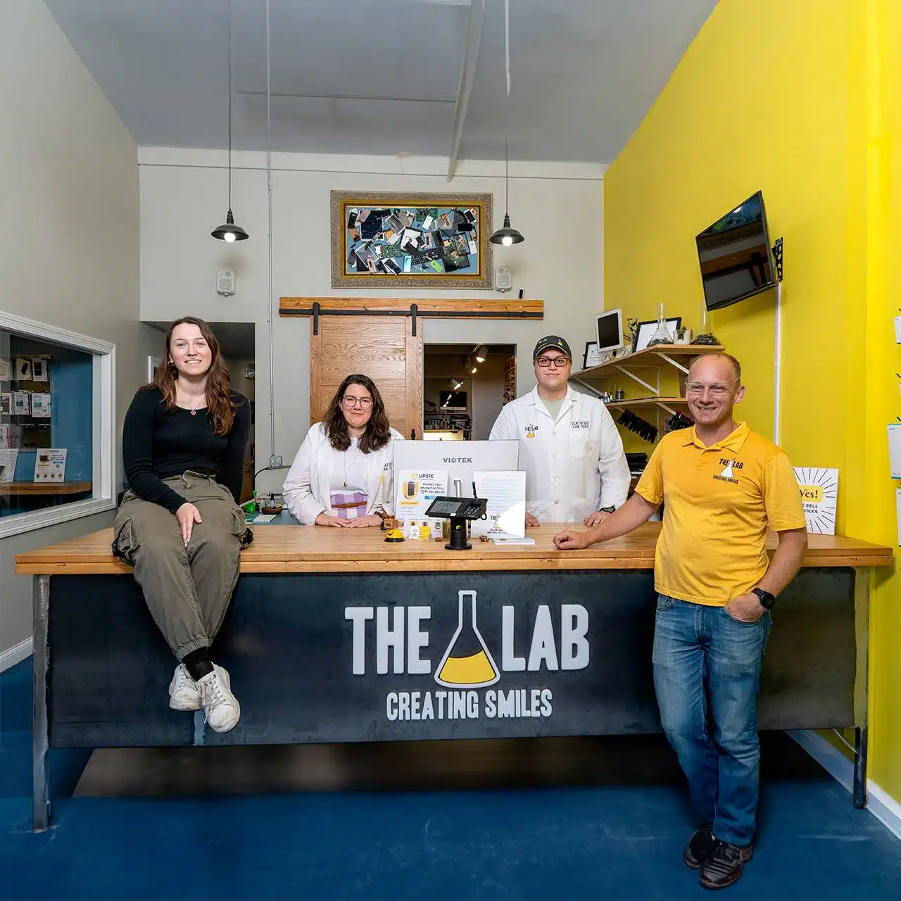 The Lab staff members standing behind the front desk counter inside The Lab