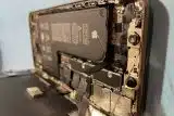 An iPhone that has been opened to show severe liquid damage on the inside of the device