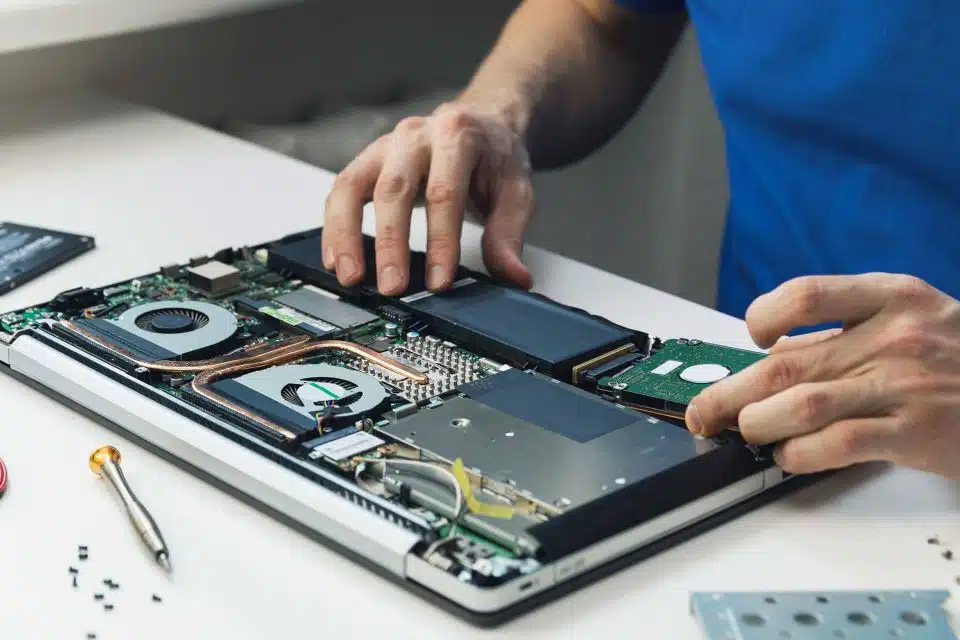 Hands repairing and replacing the hard drive of a laptop computer