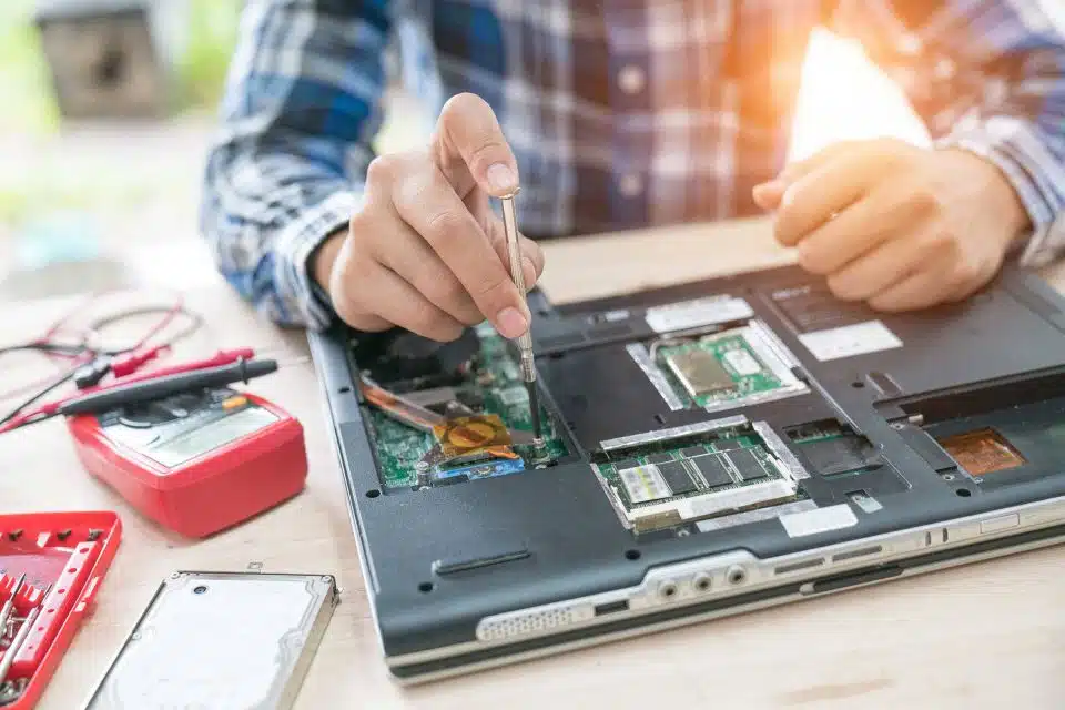 Hands repairing the interior of a laptop computer