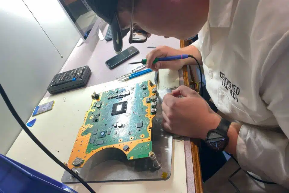 Certified Lab Tech working on repairing a broken gaming console at The Lab.