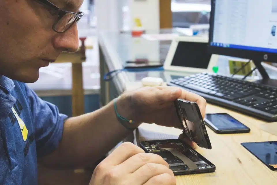 Lyle Schrock opening up a smartphone to ready it for repair at The Lab